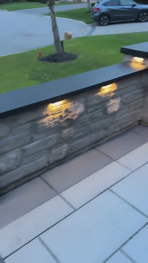 Video of illuminated dark stone steps and garden wall at dusk