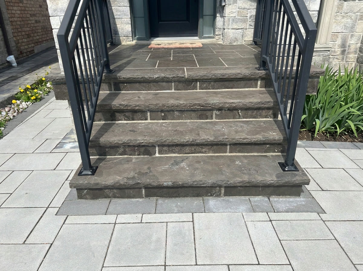 The same natural-stone steps after refinishing, without the doormat